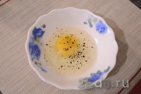 Для приготовления кляра разбить в миску яйцо, добавить немного соли и молотого чёрного перца.
