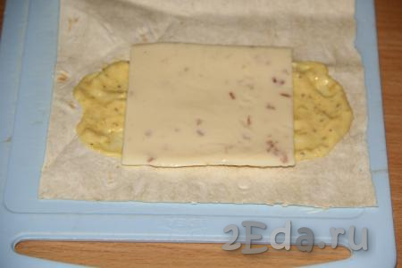 Выложить на соус пластинку плавленного сыра. Вместо плавленного сыра можно натереть на крупной тёрке любой твёрдый сыр.
