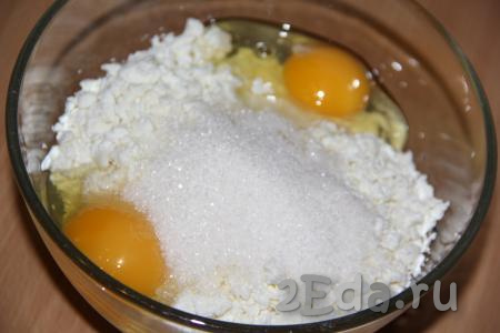 В миску с творогом добавить сахар, яйца и ванильный сахар.