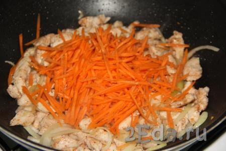 Натереть морковку на тёрке для моркови по-корейски (если такой тёрки нет, можно натереть и на крупной тёрке), добавить в сковороду. Обжарить овощи с куриным филе на среднем огне минуты 3, иногда перемешивая.