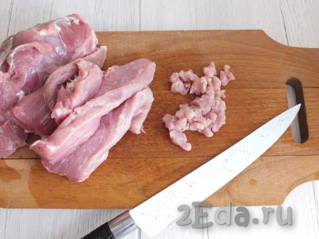 Приготовление мордовских пельменей начните с фарша. Свинину вымойте, обсушите бумажным полотенцем. Нарежьте мясо сперва на тонкие пластины, а после на кусочки размером 1 на 1 см.