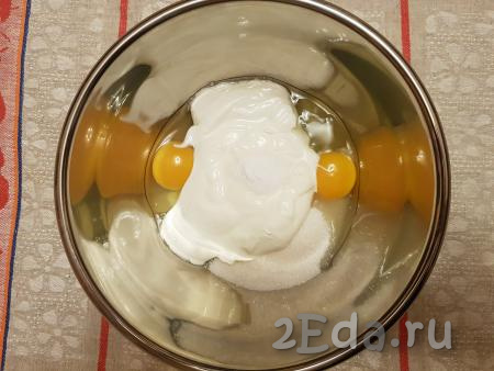 Для приготовления теста в глубокую миску разбить яйца, добавить сметану, всыпать сахар и соду.
