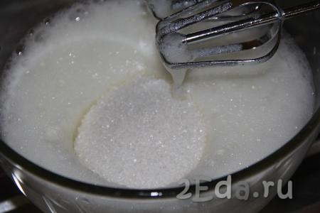 Для приготовления ванильного бисквита разделить яйца на желтки и белки. Белки взбить миксером в пышную пену, затем всыпать сахар и ванильный сахар.