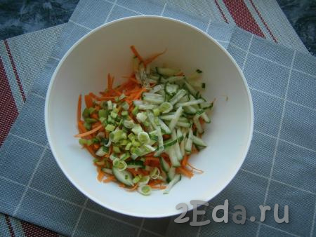 К моркови добавить  измельчённый зелёный лук и нарезанный соломкой свежий огурец.
