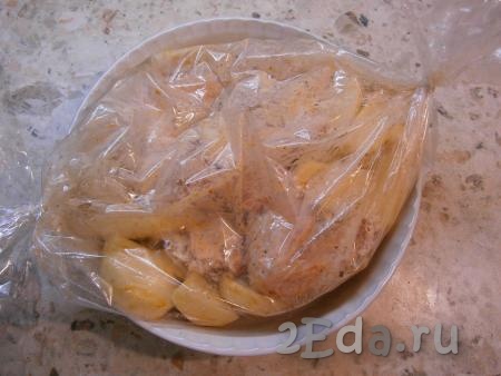 Далее выложить картофель вместе с курицей в рукав для запекания, закрепить края с двух сторон.