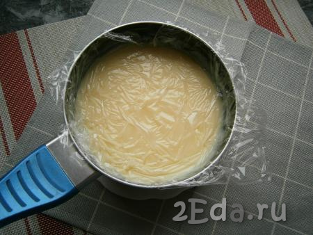 Затем накрыть заварной крем плёнкой встык (плёнка должна быть слегка прижата к крему) и оставить его остывать до тёплого состояния.