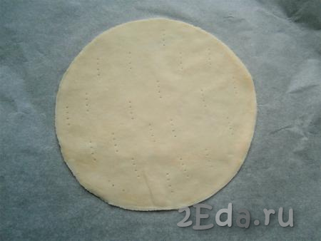 Разделить тесто на 7-8 частей. Каждую часть теста тонко раскатать и обрезать с помощью тарелки (или крышки) диаметром 19-20 см, наколоть вилкой. Получившийся круг из слоёного теста выложить на противень, застеленный бумагой для выпечки.