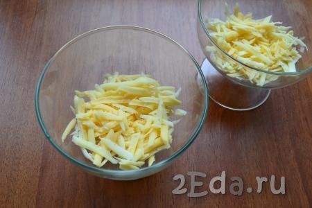 В креманки выложить первым слоем натертый на крупной терке твердый сыр.