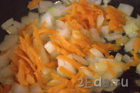 В сковороду влить растительное масло, выложить нарезанный лук и обжарить его до мягкости (в течение 3-5 минут) на среднем огне, помешивая. Затем в сковороду к луку выложить морковку, перемешать и обжарить овощи в течение 2-3 минут.