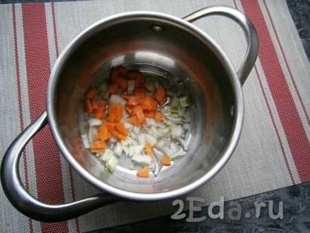 Лук, картофель и морковь очистить. Шампиньоны вымыть. Влить в толстостенную кастрюлю растительное масло, выложить морковь, нарезанную на небольшие кубики,  и нарезанный кусочками лук.