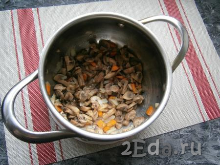 Перемешать шампиньоны с морковкой и луком и обжаривать в кастрюле, помешивая, на небольшом огне до тех пор, пока грибы не начнут поджариваться (3-5 минут).