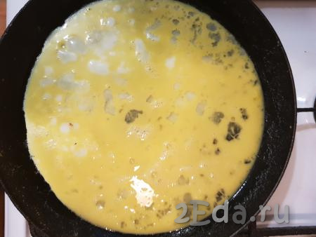 Разогреть сковороду со сливочным маслом и влить яйца, равномерно распределив по сковороде.