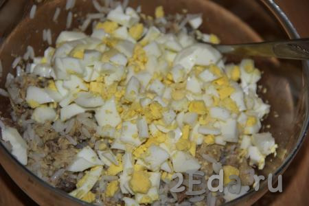 В салат из риса и консервированной скумбрии добавить яйца.