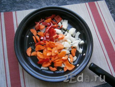 Удалить семена и плодоножку из болгарского перца, очистить лук и морковку. Лук и болгарский перец нарезать произвольно, морковку - полукружочками, выложить овощи в сковороду, влить 3 столовые ложки растительного масла.