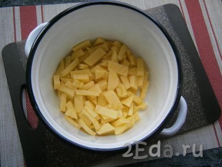 Очистить лук, картофель и морковь, удалить плодоножку с семенами из болгарского перца. Картошку нарезать на небольшие кусочки и поместить в кастрюлю.