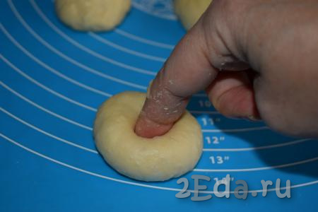 Далее каждый шарик нужно проткнуть пальчиком в самом центре, делая таким образом дырочку (этот способ формирования пончиков гораздо проще, чем способ с вырезанием дырочки при помощи крышечки или ещё какого-нибудь другого приспособления).