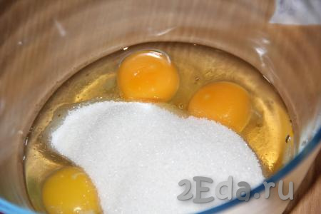 Вбить 3 яйца в глубокую миску, всыпать сахар.