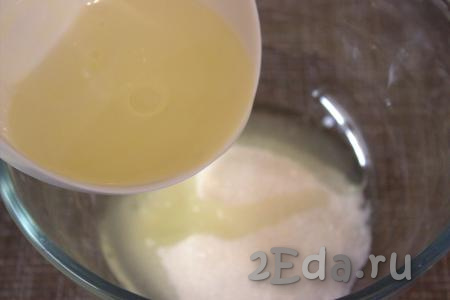В глубокую миску насыпать сахар, добавить ванильный сахар и растительное масло, перемешать.