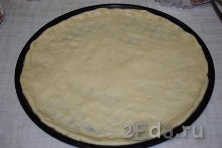 Достаем тесто из миски и распределяем его равномерно по форме, в которой будет выпекаться пицца (при желании, форму можно смазать маслом или застелить бумагой для выпечки). Я использую большую форму диаметром 34 см.