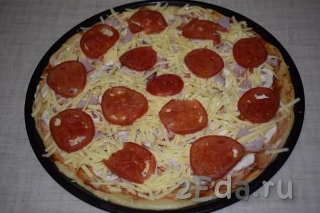 Пиццу с шампиньонами и колбасой посыпаем сыром, натертым на крупной терке, сверху выкладываем помидоры, нарезанные на кружочки.