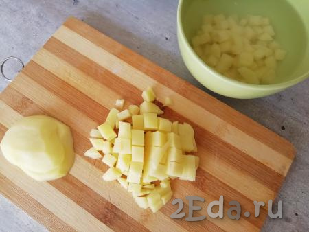 Картофель нарезать на средние кубики (или брусочки) и поместить в холодную воду.