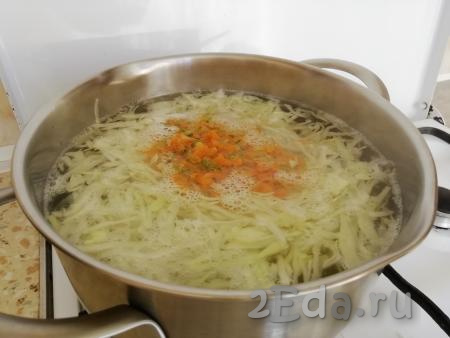 По истечении времени добавить в кастрюлю капусту и обжаренные лук с морковкой, варить ещё 10 минут.