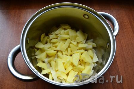 Картошку, лук и морковь очистить. В кастрюлю нарезать небольшими кусочками картофель, затем влить 2 литра воды, поставить на огонь, довести до кипения, снять пену, огонь уменьшить и варить картошку 20 минут.