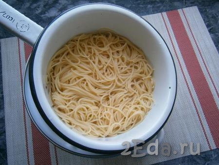 Откинуть отваренные спагетти на дуршлаг и дать стечь воде.