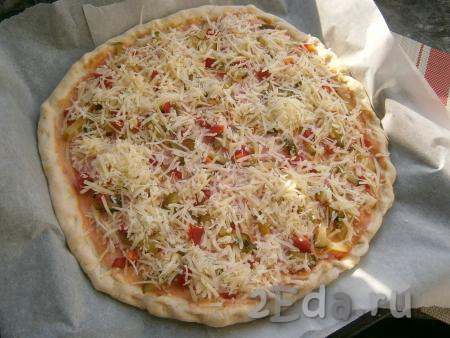 Сыр натереть на средней тёрке и щедро  посыпать пиццу сверху.