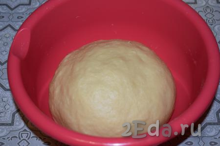 Далее вымешиваем тесто руками не менее 10 минут. По консистенции тесто получается плотным, гладким и совсем не липнет к рукам. Оставляем его на расстойку, накрыв миску плёнкой, на 1 час.