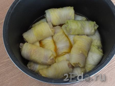 Подготовленные голубцы из пекинской капусты выложите в чашу мультиварки на зажарку из лука и моркови.