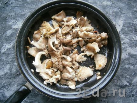 Выложить нарезанные вешенки на сковороду, разогретую с растительным маслом, и обжаривать, периодически помешивая, на среднем огне минут 5. Посолить грибы и поперчить, посыпать приправой.