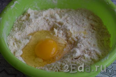 К крошке добавляем яйцо и сметану, начинаем вначале ложкой, а затем руками замешивать тесто.