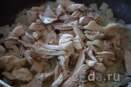 В сковороду к луку добавить куриное мясо, отделённое от костей и нарезанное на кусочки, обжаривать, помешивая, на среднем огне, примерно, 1-2 минуты.