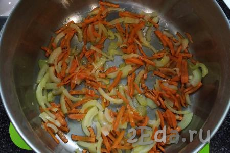 Пока куриные желудочки варятся, займёмся приготовлением зажарки из моркови и лука. Для этого чистим морковку и лук. Нарезаем  полукольцами лук, а морковь - тонкими брусочками. В кастрюлю с толстым дном (или в сковороду), в которой будут тушиться куриные желудочки, наливаем, примерно, 30 мл рафинированного растительного масла, выкладываем лук с морковью и обжариваем их на среднем огне до лёгкой золотистости, не забывая периодически помешивать. 