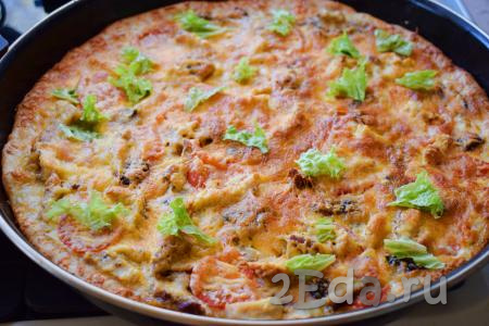 Отправляем пиццу с шампиньонами и курицей в разогретую духовку и выпекаем в течение 30-35 минут при температуре 180 градусов. Готовую пиццу достаём из духовки, посыпаем орегано (можно посыпать и зеленью).