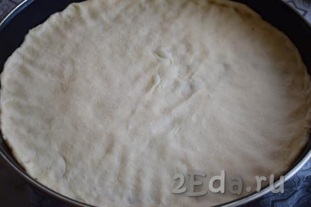 Подошедшее тесто распределяем по дну формы диаметром 42 см. Можно использовать противень, из этого количества теста получается большая пицца.