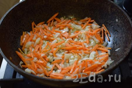 Разогреем большую сковороду, в которой будем готовить плов. Сковорода обязательно должна быть с плотно прилегающей крышкой. В сковороду нальём растительное масло, добавим нарезанные лук и морковь. Обжарим овощи на среднем огне в течение 9-10 минут, периодически помешивая.
