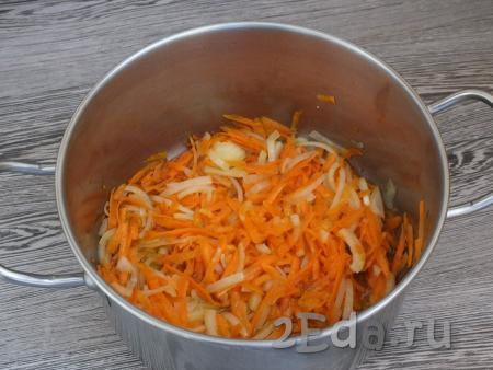 Почистите лук и морковь. Лук нарежьте полукольцами, морковь натрите на крупной тёрке. Для приготовления плова из полбы с курицей возьмите глубокую кастрюлю с толстым дном (или казан), налейте в неё масло и раскалите на среднем огне. Выложите подготовленные морковку с луком в разогретое масло, обжаривайте на среднем огне, помешивая, в течение 10 минут.