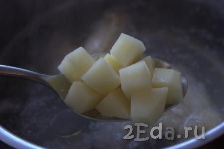 После того как в бульон будет возвращено куриное мясо, отделённое от костей, выложить в суп нарезанную картошку и варить минут 20 (до готовности картошки).