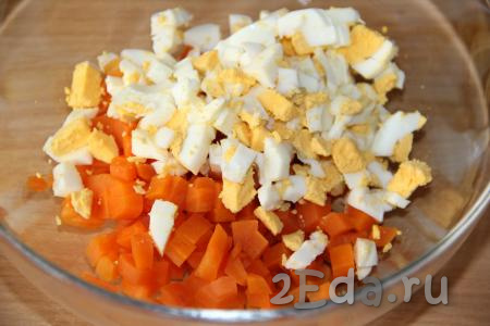 Сварить вкрутую яйца (на варку потребуется минут 10 с момента начала кипения воды), а затем остудить их, почистить, нарезать на кубики и выложить в миску с варёной морковкой.