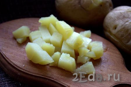 Остывший картофель почистить и нарезать на кубики среднего размера.