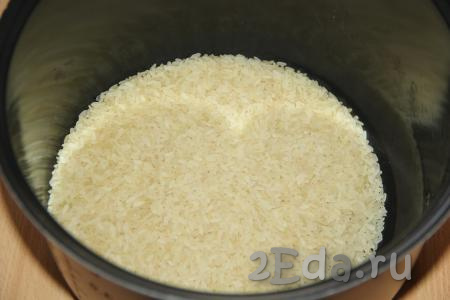 Если используете пропаренный рис, то промывать его не нужно. Если используете простой рис, то хорошо промойте его проточной водой. Выложить рис в кастрюлю с толстым дном (или чашу мультиварки).