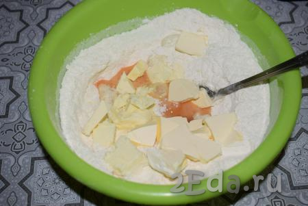 Далее отправляем в миску яйцо и охлаждённое сливочное масло, нарезанное на небольшие кусочки.