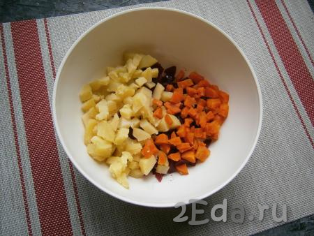 Морковку с картофелем тоже нарезать на небольшие кубики, а затем выложить к свекле, смешанной с маслом.