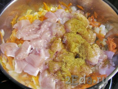 Затем в сковороду с морковкой и луком кладём кусочки куриного филе, посыпаем приправой хмели-сунели и жарим, постоянно перемешивая, на достаточно сильном огне, примерно, 1,5 минуты.