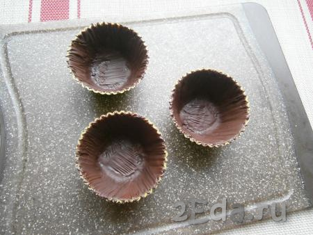 С помощью кисточки силиконовые формочки для кексов полностью смазать внутри растопленным шоколадом, поместить в холодильник на 10 минут. После этого смазать вторым слоем растопленного шоколада и отправить в холодильник ещё минут на 10. Шоколад должен полностью застыть.