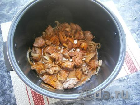 Полуготовую печёнку залить соусом, посыпать приправой для курицы, добавить измельчённый зубчик чеснока.