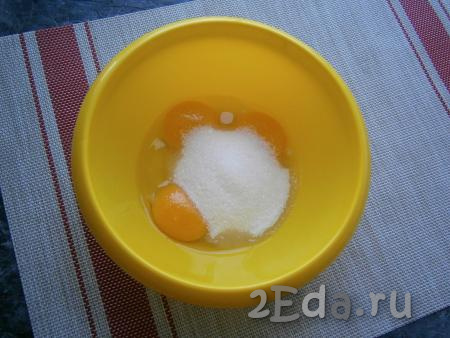 К двум сырым желткам добавить одно целое яйцо, всыпать сахар.