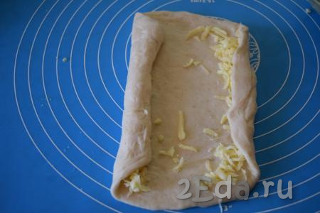 Сворачиваем тесто с двух сторон, накрывая сыр по краям нашего хачапури.